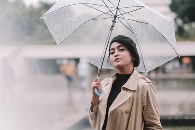 女人棕色大衣拿着伞
